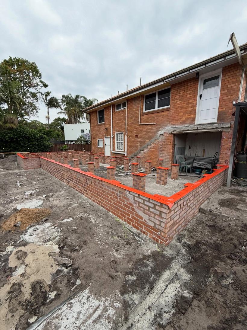 Subfloor for an extension and deck behind a brick home
